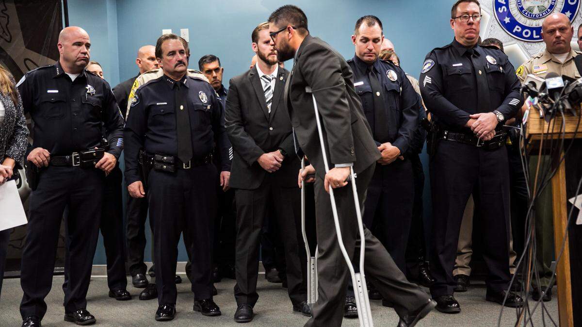 Officer Nicholas Koahou, from San Bernardino Police Department, walks away from the podium in crutches after talking about about facing the attackers during the pursuit and what he did after getting shot in the thigh during a press conference with first responders who worked during that day on Dec. 8, 2015 in San Bernardino, Calif. (Marcus Yam/Los Angeles Times/TNS)