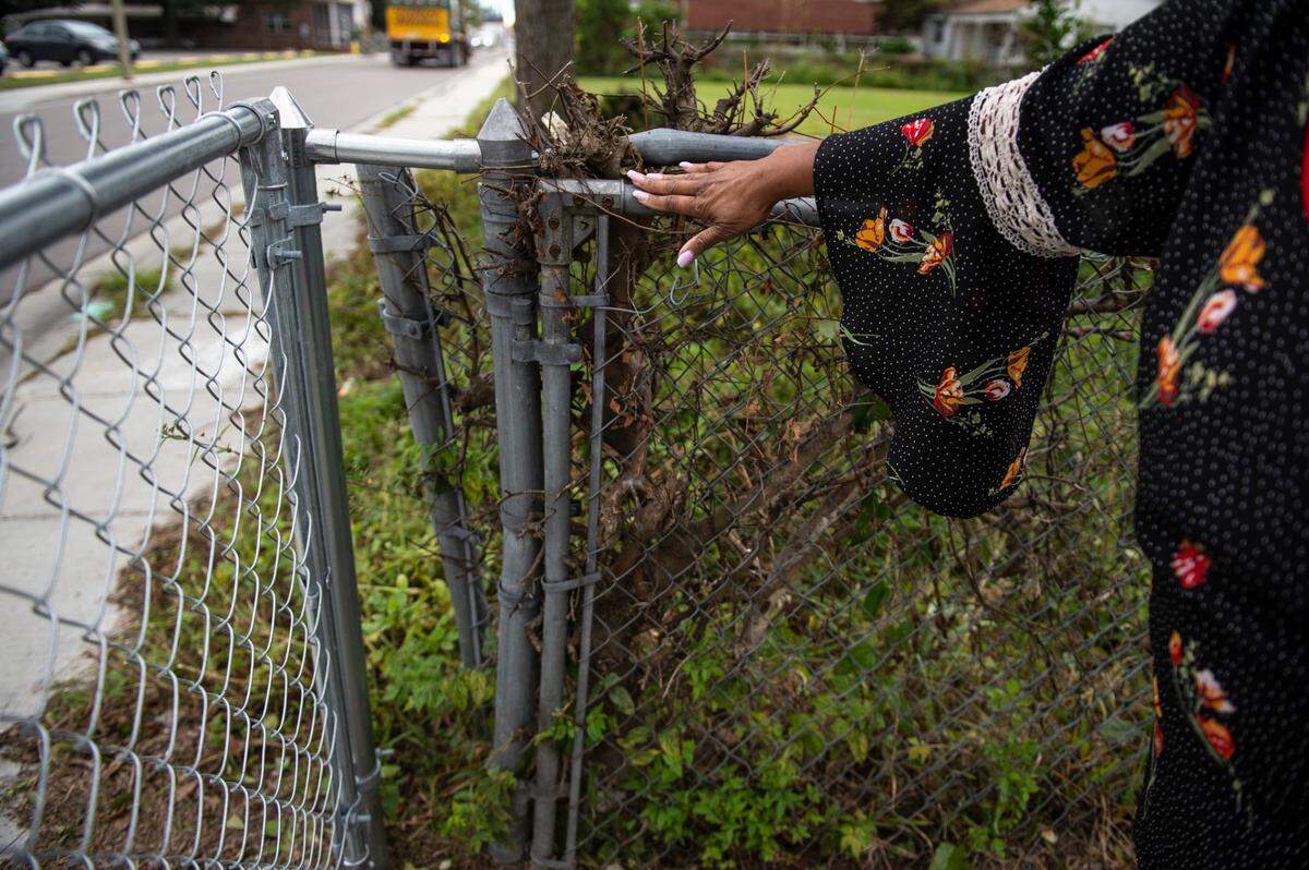 Karen Fleeton points out her fence outside her home in East Biloxi on Friday, Oct. 29, 2021. She says that when Oscar Renda did the repairs, they opened the fence gate, leaving it to become absorbed by vines and then left it there. When they repaired the fence gate, they left a large gap between the original fence and the new gate.