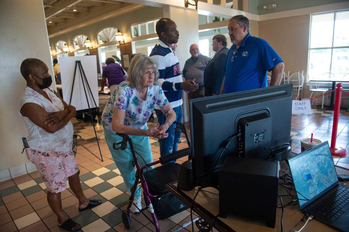 Members of the public watch a video by the City of Gulfport on stormwater mitigation that a road project west of Highway 49 claims to provide during a public hearing on the road project at Gulfport Premium Outlets in Gulfport on Wednesday, July 13, 2022.