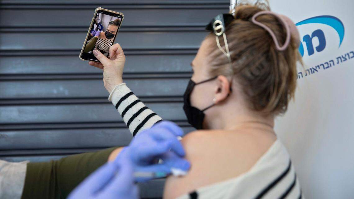 Social media selfies of people receiving the COVID vaccine have drawn mixed reactions among public health experts and critics. (AP Photo/Sebastian Scheiner)