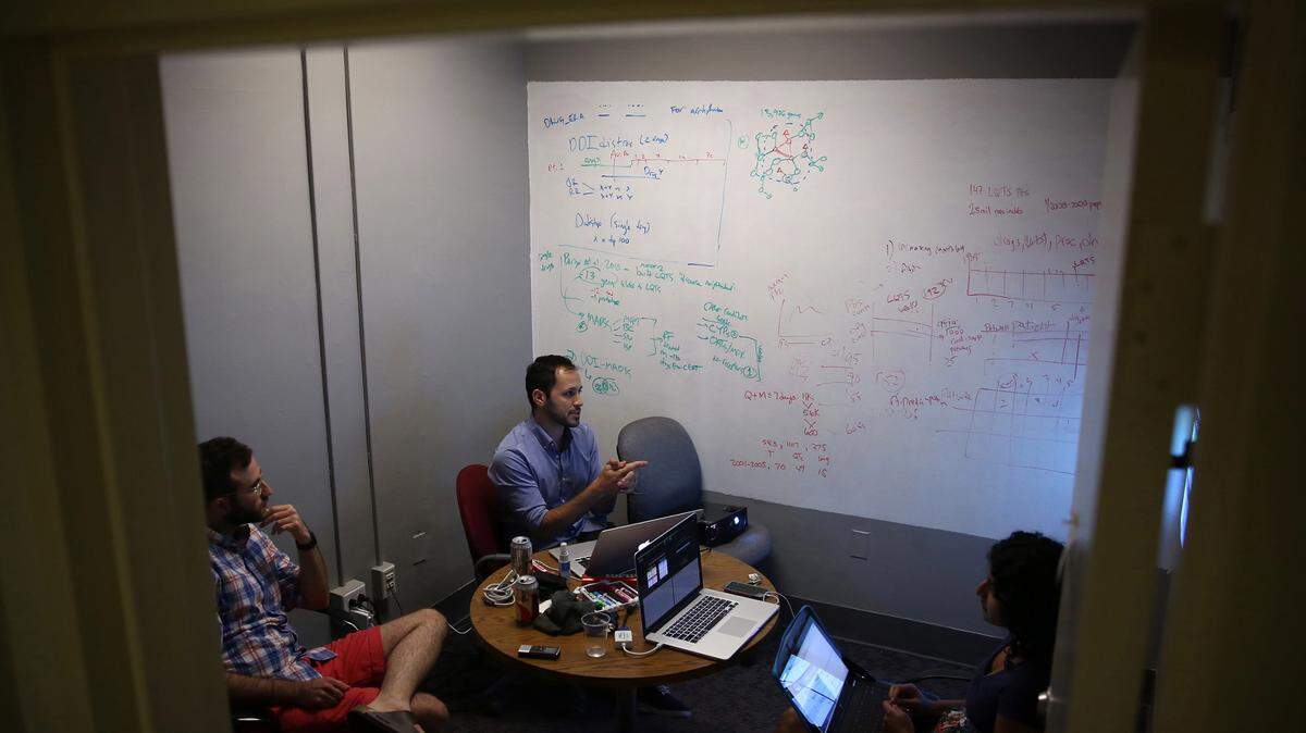 Using a wall he coated with special white-board paint, Columbia University data scientist Nick Tatonetti, center, works through calculations crucial to the algorithms needed to find hidden drug interactions in New York on August 20, 2014. Working with him are doctoral students Tal Lorberbaum, left, and Phyllis Thangaraj. (E. Jason Wambsgans/Chicago Tribune/TNS)