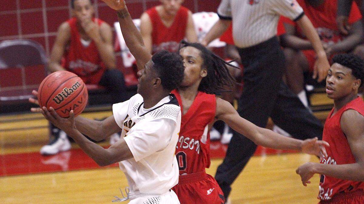 TIM ISBELL/SUN HERALD 
 Harrison Central's Jonathan Biscuit Floyd tries to block the shot of D'Iberville's Zachary Scales, Friday, Dec. 18, 2015.
