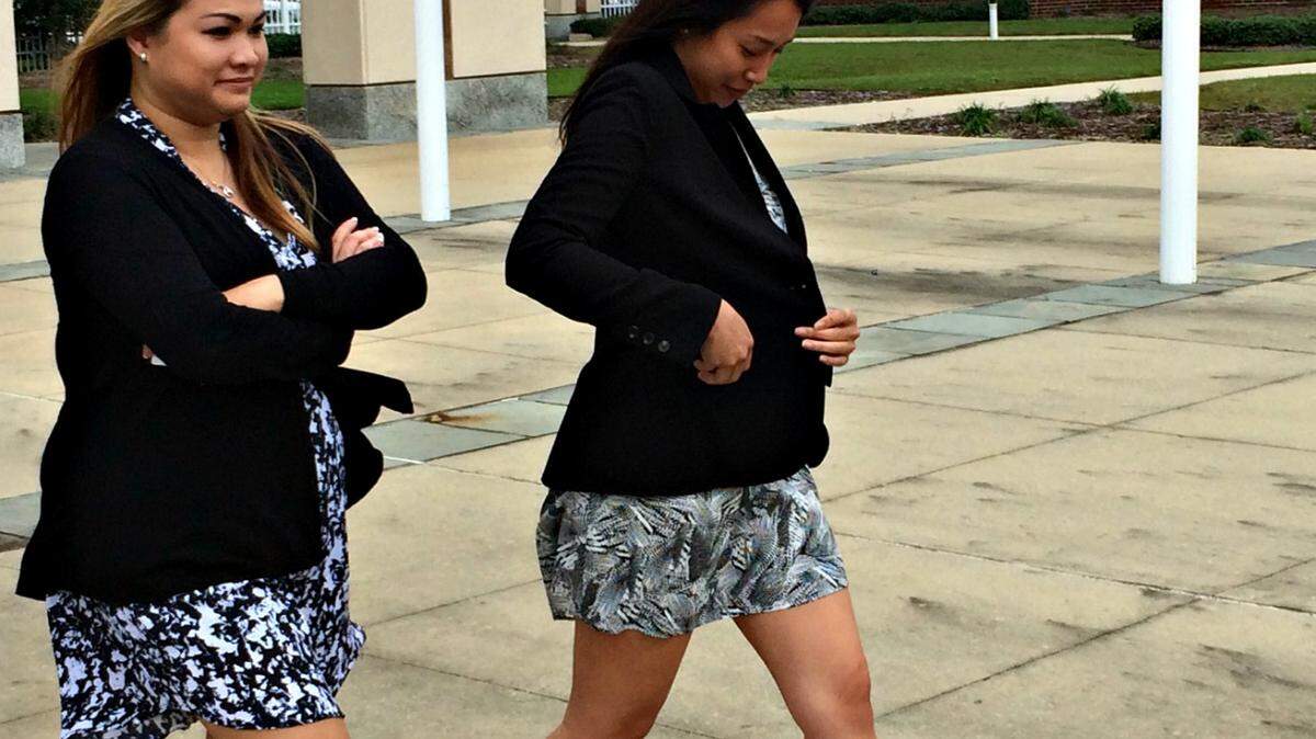 ANITA LEE/SUN HERALD 
 Thi Houng "Kristy" Le, left, of Grand Bay, Ala., was the seventh person to plead not guilty to charges in a 95-count indictment that outlines a conspiracy to submit fraudulent claims over the 2010 BP oil catastrophe. Le and an unidentifed supporter are seen leaving the federal courthouse in Gulfport on Monday.