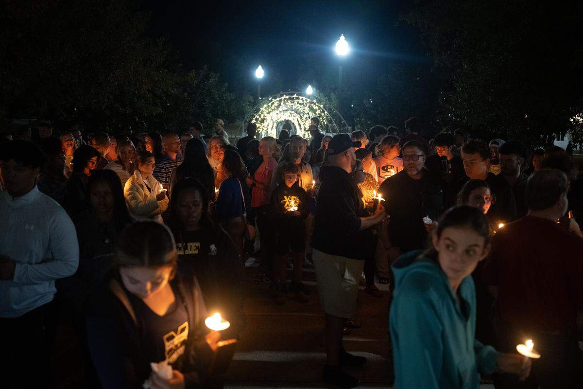 Vigil attendees gather in front of a campus chapel.