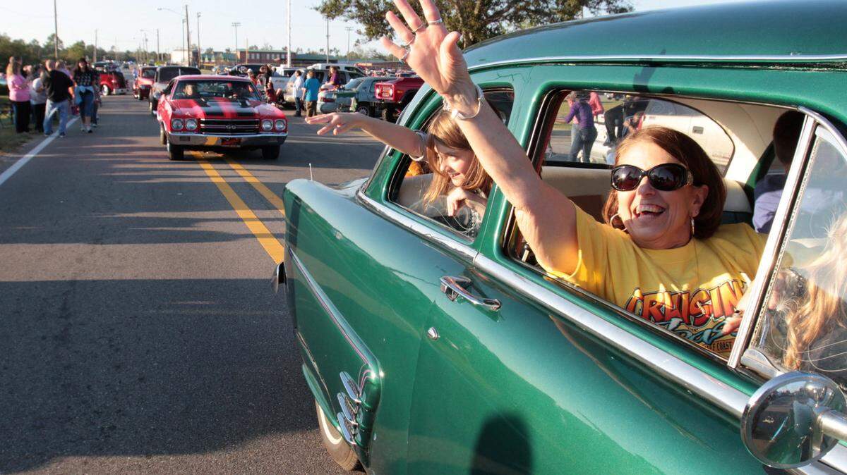 Participants toss throws during the Cruisin’ The Coast parade in Long Beach on Monday Oct. 8, 2012.