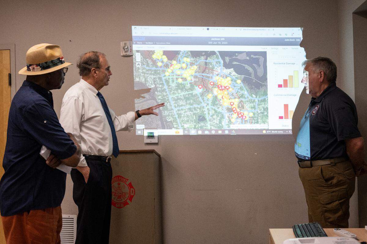 Jackson County Emergency Manager Earl Etheridge shows Lt. Gov. Delbert Hosemann and Moss Point Mayor Billy Knight a map of tornado damage at the Moss Point Fire Department on Wednesday, June 21, 2023.