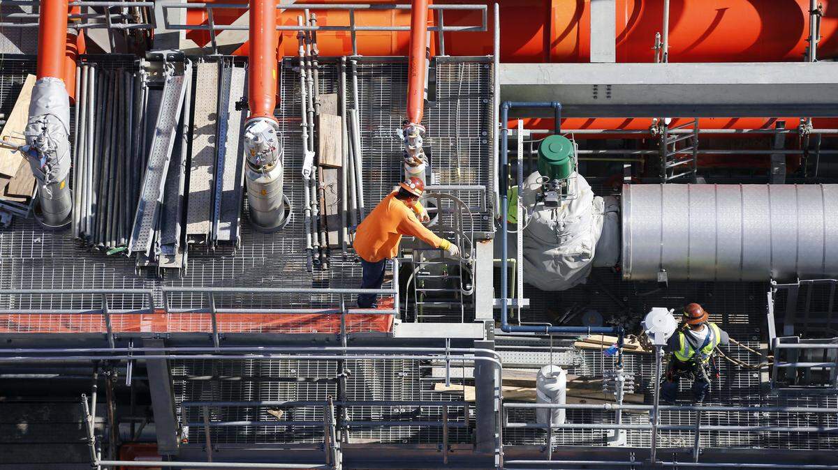 In this Nov. 16, 2015 photo, employees work next to the gas lines of the Mississippi Power Co. carbon capture power plant in DeKalb, Miss. The construction costs for the plant have grown to about $6.4 billion and it has been repeatedly delayed, but Southern Company, owners of Mississippi Power stand by the plant as a model for burning coal while emitting less carbon dioxide and hope to market its key technology. (AP Photo/Rogelio V. Solis)