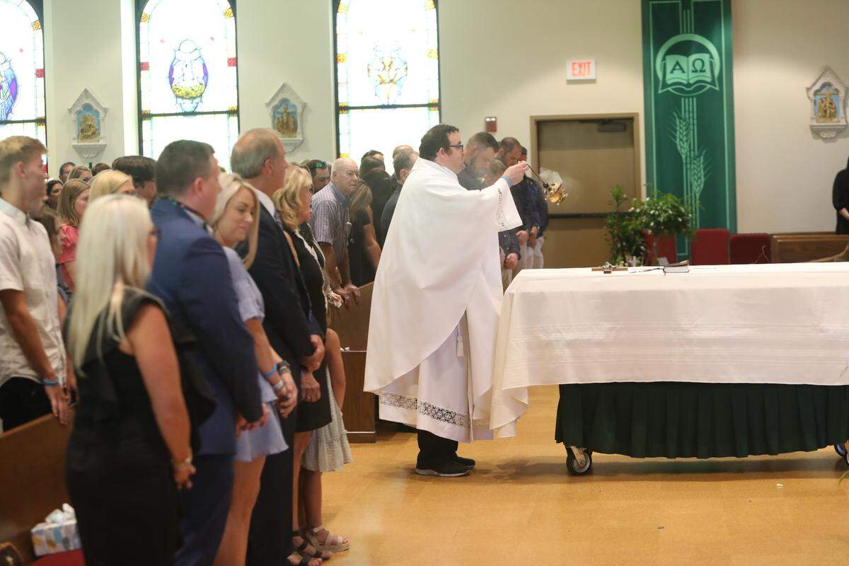 The Rev. Braxton Necaise prays over the casket of Cayce Seal on July 1, 2021, during funeral services at St. Clare Catholic Church in Waveland.