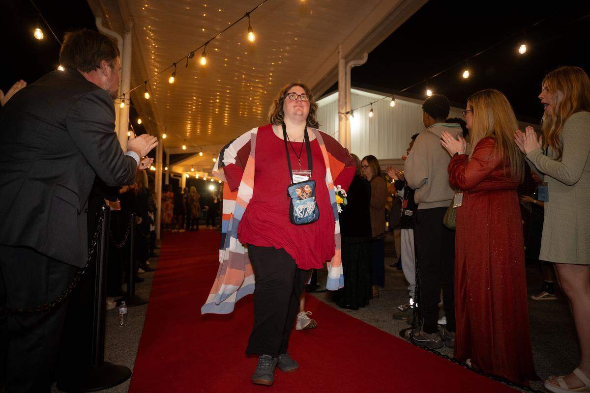 Samantha Strata’s walks the red carpet as volunteers cheer her on during Night to Shine at Woolmarket Baptist Church on Friday, Feb. 13, 2026.