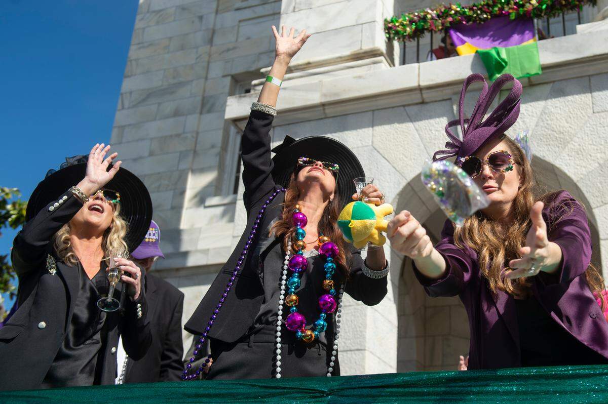 Paradegoers catch beads in front of city hall during the Gulf Coast Carnival Association’s Mardi Gras parade in Biloxi on Tuesday, Feb. 13, 2024.