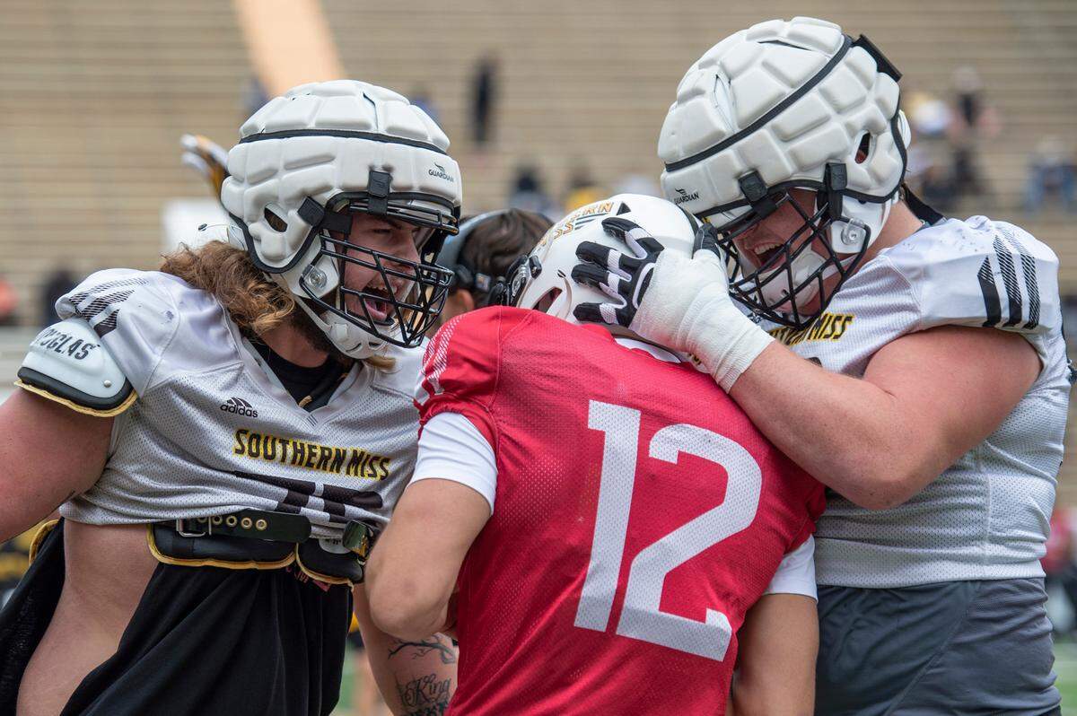 Offensive lineman Peyton McKinnon, left, embraces quarterback Zach Wilcke after a play during the Spring Game at M.M. Roberts Stadium in Hattiesburg on Friday, April 1, 2022.