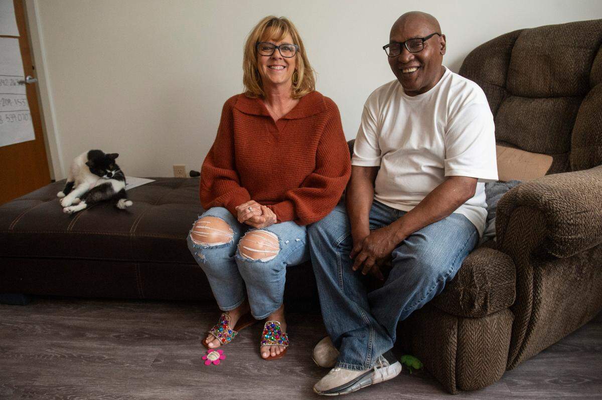 Clifton Williams, right, poses for a photo with Cathy Pitalo, planning coordinator at Open Doors, and Williams’ cat Felix at Williams’ apartment in Gulfport on Friday, April 11, 2025. Through the help provided by Open Doors and the companionship of his cat, Williams has been able to live independently in an apartment for a year.