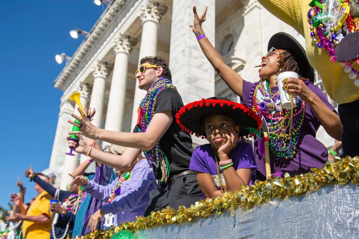 Kimley Miller, 7, watches the floats go by during the Gulf Coast Carnival Association Mardi Gras Parade in Biloxi on Tuesday, March 1, 2022. Miller got tired of the floats after a while, her mother said.