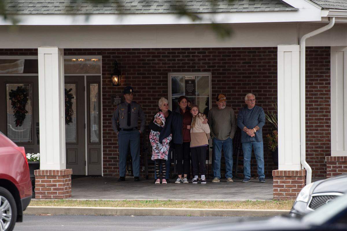 Family waits as a procession escorting George County Sheriff’s officer Jeremy Malone, who was killed on Thursday, arrives at Moments Funeral Home in Lucedale on Jan. 5.