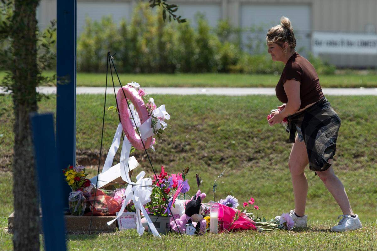 Vanessa Owens places tributes at a monument to a 13-year-old outside the Ocean Springs Middle School on Thursday, Sept. 7, 2023. The child, Aubreigh Wyatt, died unexpectedly after being bullied and her death is under investigation.