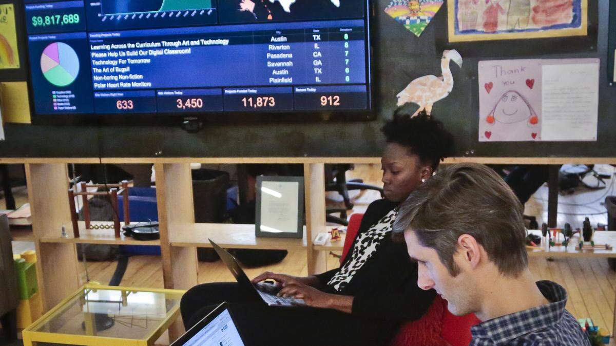 Charles Best, right, CEO of DonorsChoose.org, and Rakey Drammeh, CEO assistant, work near a large graphics monitor displaying realtime donations trending around the country for teacher's projects, Wednesday, March 9, 2016, in New York. Wish lists posted on the education philanthropy website DonorsChoose.org are being fulfilled in a "flash funding" effort involving actors, pro athletes, tech titans and others. (AP Photo/Bebeto Matthews)
