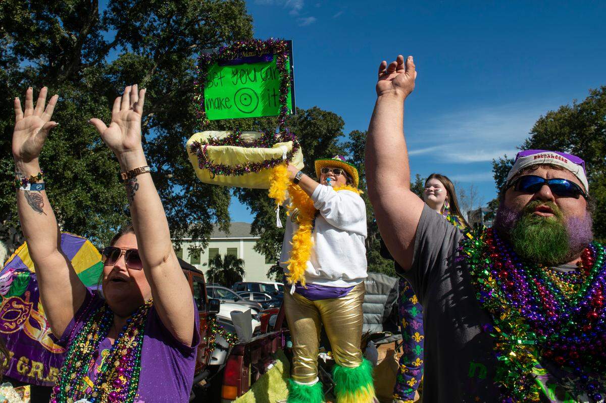 Paradegoers catch beads during the Gulf Coast Carnival Association’s Mardi Gras parade in Biloxi on Tuesday, Feb. 13, 2024.