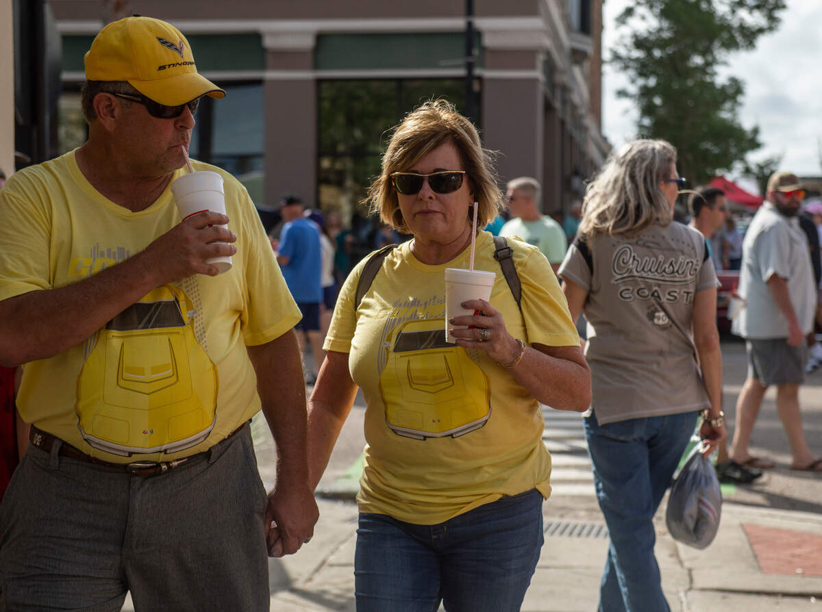 A couple wears matching Corvette themed outfits during View the Cruise in downtown Gulfport on Sunday, Oct. 3, 2021.