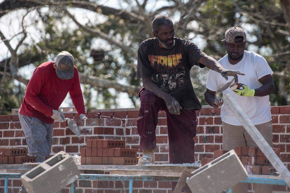 Workers hired by Jeffrey Reed’s construction company work on building a brick wall around MLK Park as a part of renovation efforts in the Third Ward in Bay St. Louis on Thursday, March 17, 2022.
