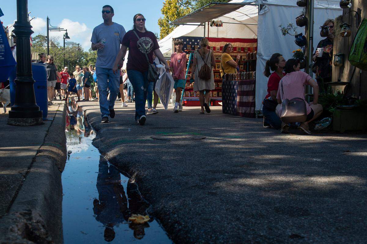People walk among tents selling art along Government Street during the Peter Anderson Festival in Ocean Springs on Sunday, Nov. 6, 2022.