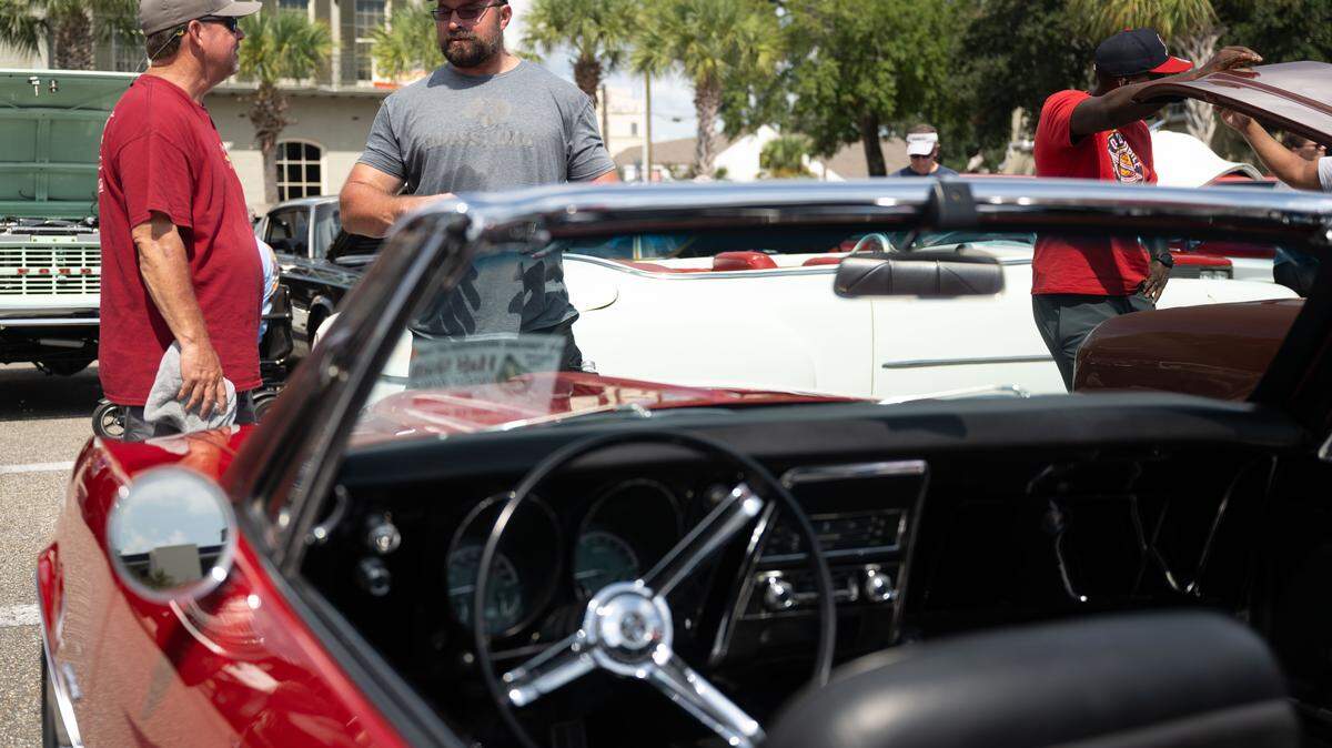 Blane Solar, left, talks to a passerby about his 1967 Chevrolet Camero during the Biloxi Block Party on Wednesday, Oct. 8, 2025.