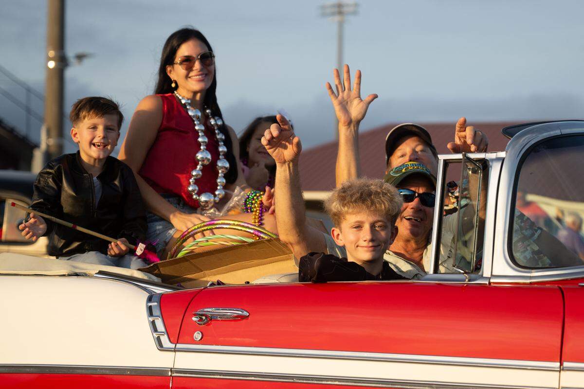 The Tuminello family waves as they leave the lot of Long Beach High School during the Long Beach Cruisin’ The Coast Parade on Monday, Oct. 6. It could be a record year for Cruisin’ The Coast.