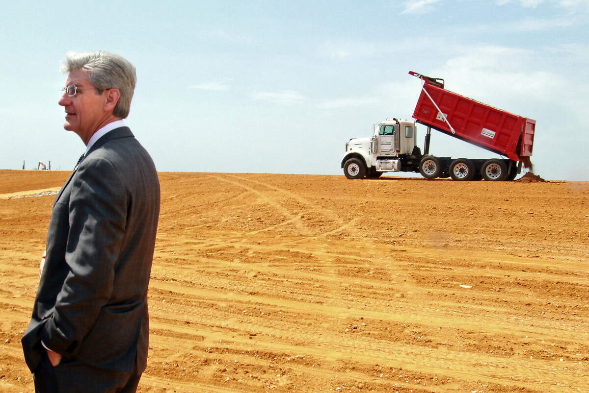Gov. Phil Bryant is on hand as the last truckload of fill is dumped on the expanded West Pier at the state port in Gulfport on Wednesday, April 10, 2013. A channel deepening was initially supposed to be included in the $570 million elevation and expansion project, but was found to be economically unfeasible.