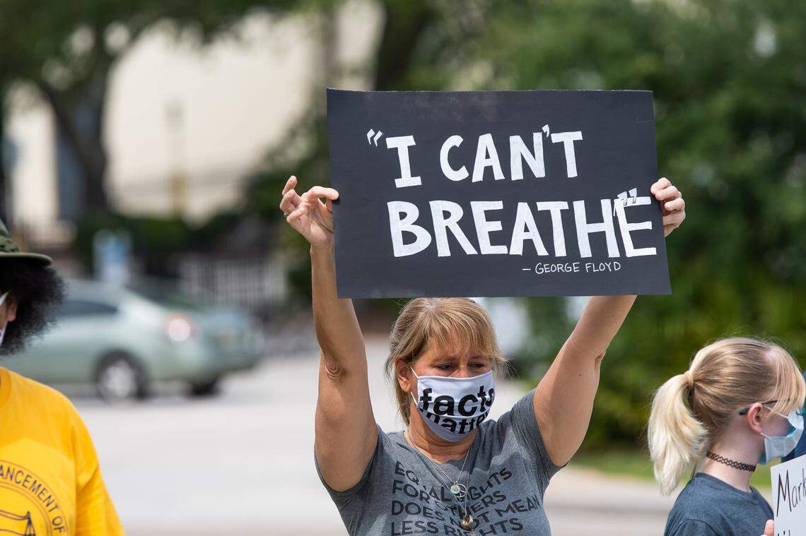 A protester holds a sign referencing the final words of George Floyd, whose death has sparked protests across the country.