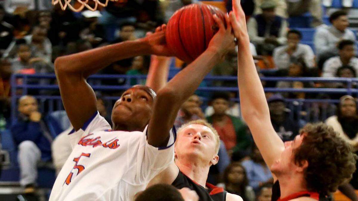 AMANDA McCOY/SUN HERALD 
 Gulfport's Dequarius McCord, left, grabs the rebound from Metamora's Jordan Dehm, right, and Noah Persich, center, as the buzzer sounds to end the first quarter of the championship game of the Gulfport Hardwood Holiday Classic on Wednesday, December 30, 2015.