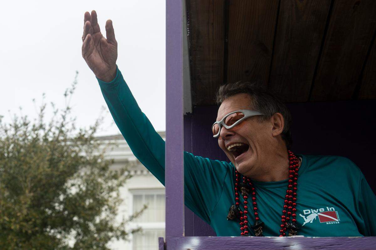 A float rider throws beads from a float during the Krewe of Gemini parade in downtown Gulfport on Saturday, Feb. 10, 2024.
