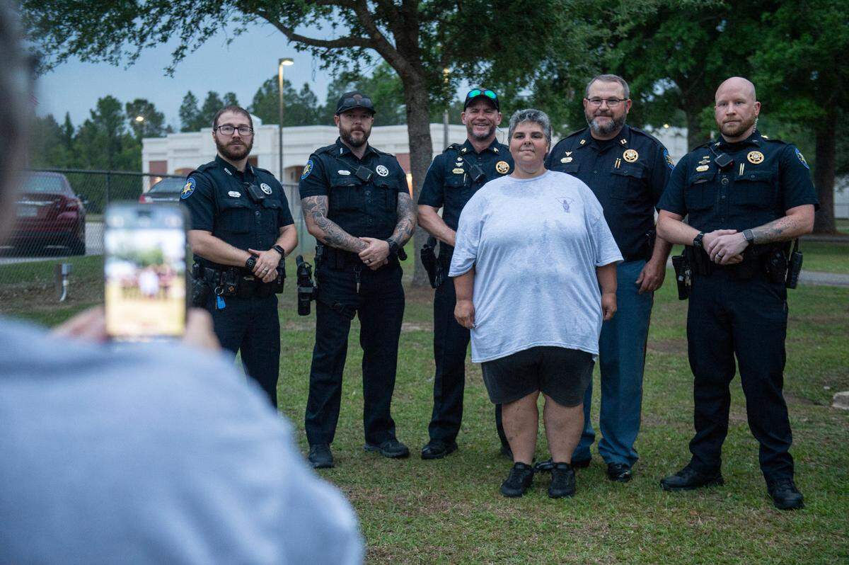 Vickie Wedgeworth Hutcherson, the mother of Gracelynn Vick, takes a photo with Harrison County Sheriff’s deputies, who helped search for Gracelynn, during a candlelight vigil for Gracelynn at Saucier Park on Tuesday, April 22, 2025.