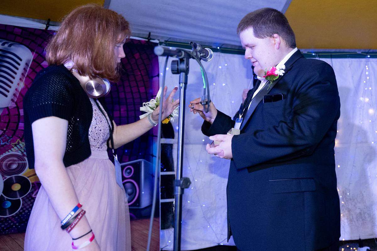 Anthony Payne, right, proposes to Mae Davis, left, during Night to Shine at Woolmarket Baptist Church on Friday, Feb. 13, 2026.