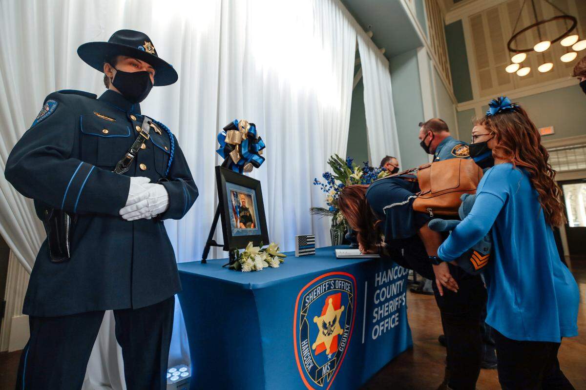 Mourners sign the guest book at the funeral for Lt. Michael Boutte at the Bay St. Louis Community Hall on Tuesday, Feb. 9, 2021.
