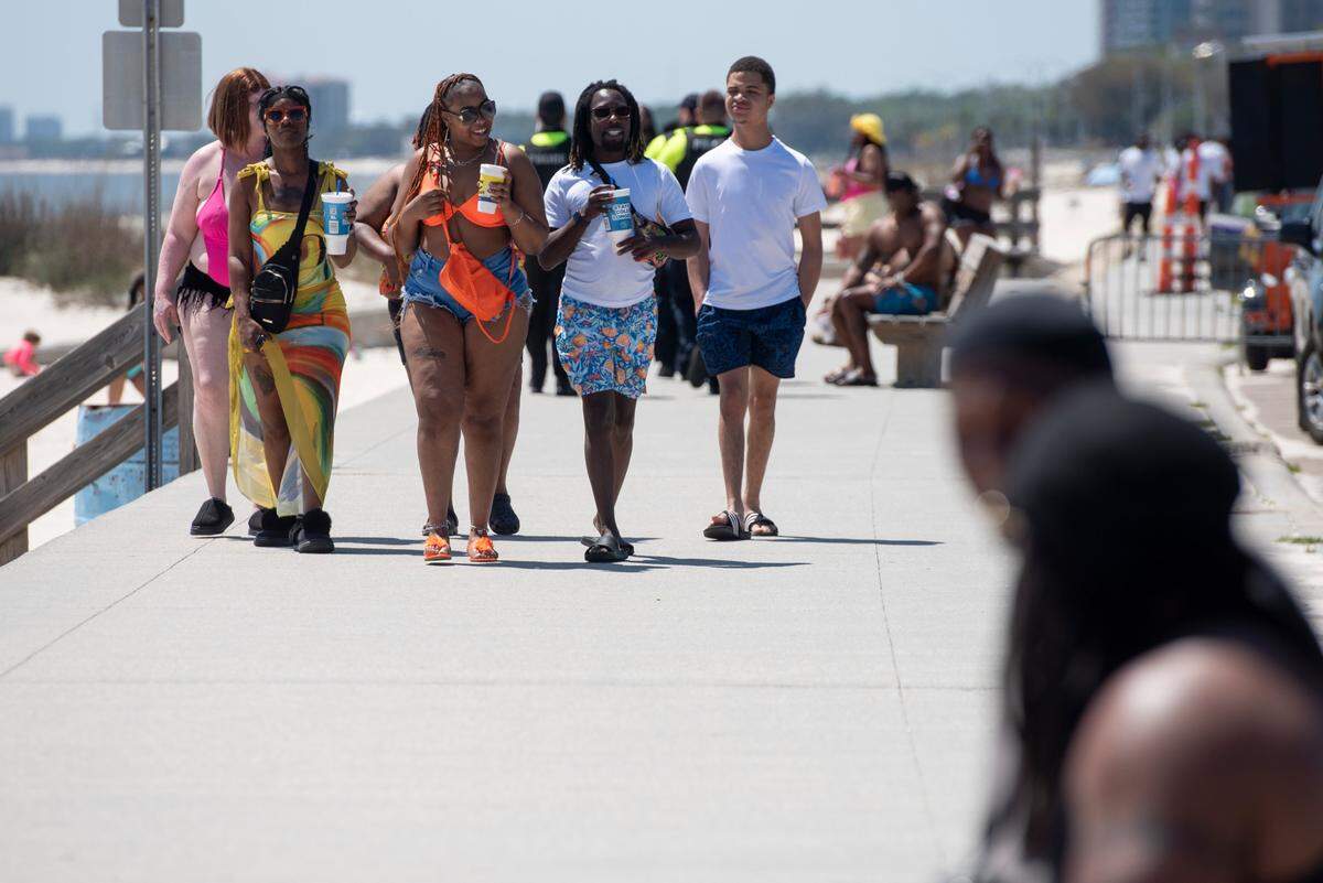 Spring breakers walk along Biloxi Beach during Black Spring Break on Saturday, April 12, 2025.