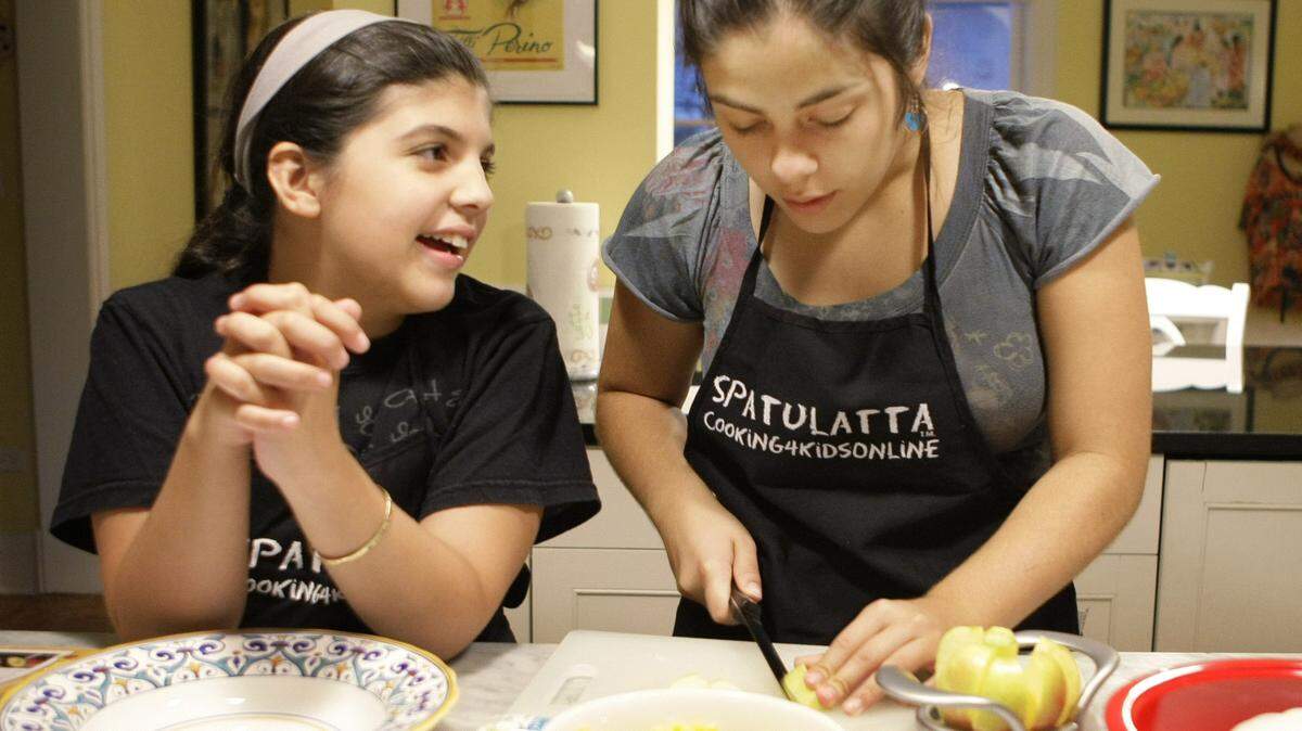 In this photo taken Sept. 17, 2009, the Spatulatta sisters, better known as child cooks 13-year-old Isabella Gerasole, right, and 11-year-old Olivia, prepare dinner and talk about their school day at home in Evanston, Ill. (AP Photo/Charles Rex Arbogast)