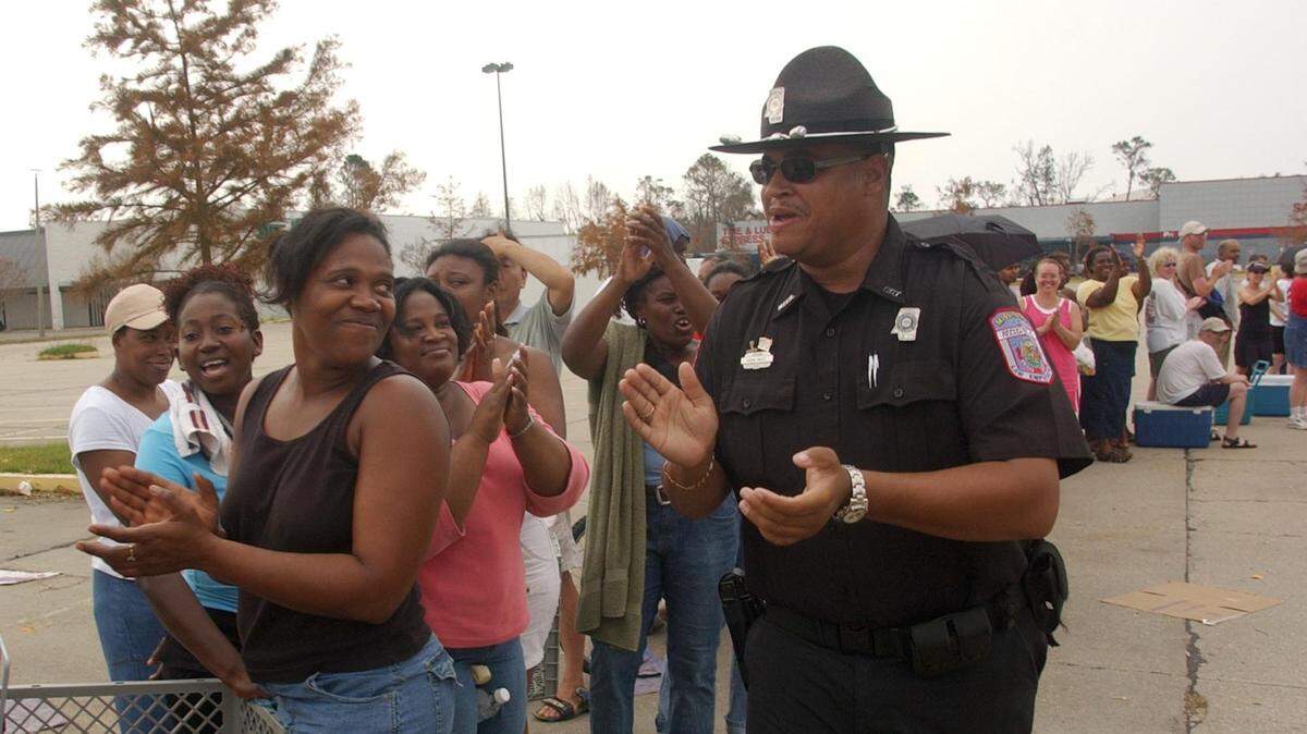 Mississippi Department of Transportation officer David West cheers up Hurricane Katrina survivors on Sept. 1, 2005, as they stand in line at a FEMA ice and water distribution center in front of Walmart in Biloxi, Miss. West said a positive attitude is important to getting through a disaster.