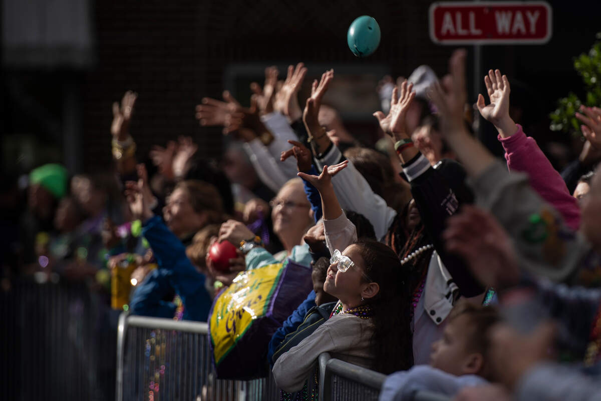 Parade attendees cheer for beads during The Ocean Springs Elks Carnival Parade in downtown Ocean Springs on Saturday, Jan. 27, 2024.