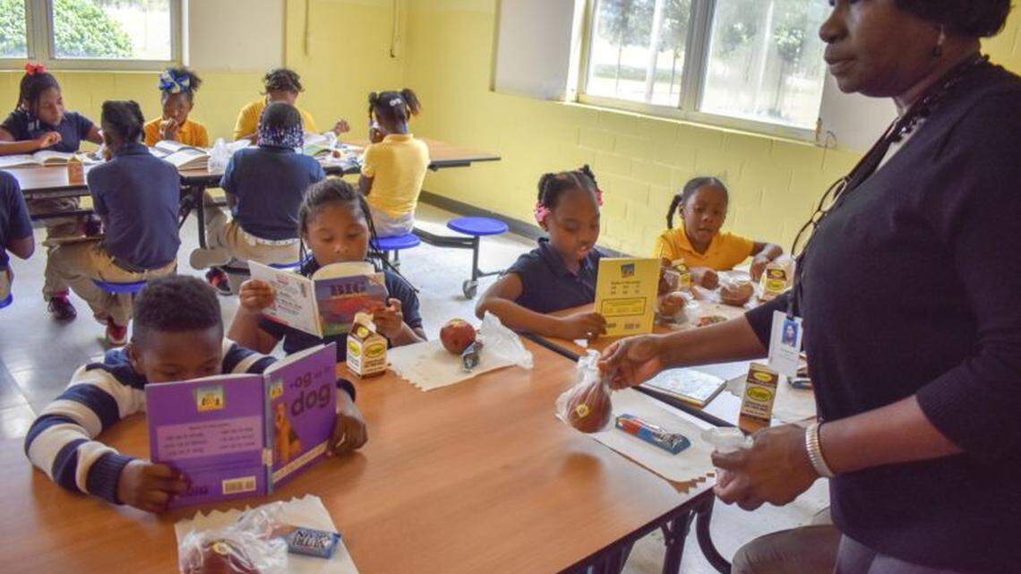 Earnestine Keys, teacher at Jonestown Elementary School, hands out snacks to students during their read and snack time at the beginning of the after-school program on May 16.