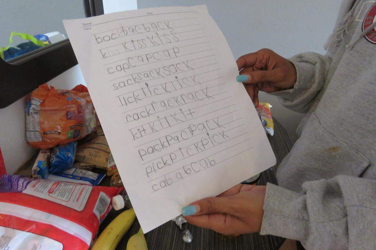 Samantha Dees holds a spelling and handwriting worksheet completed by her 7-year-old son on Sept. 4.