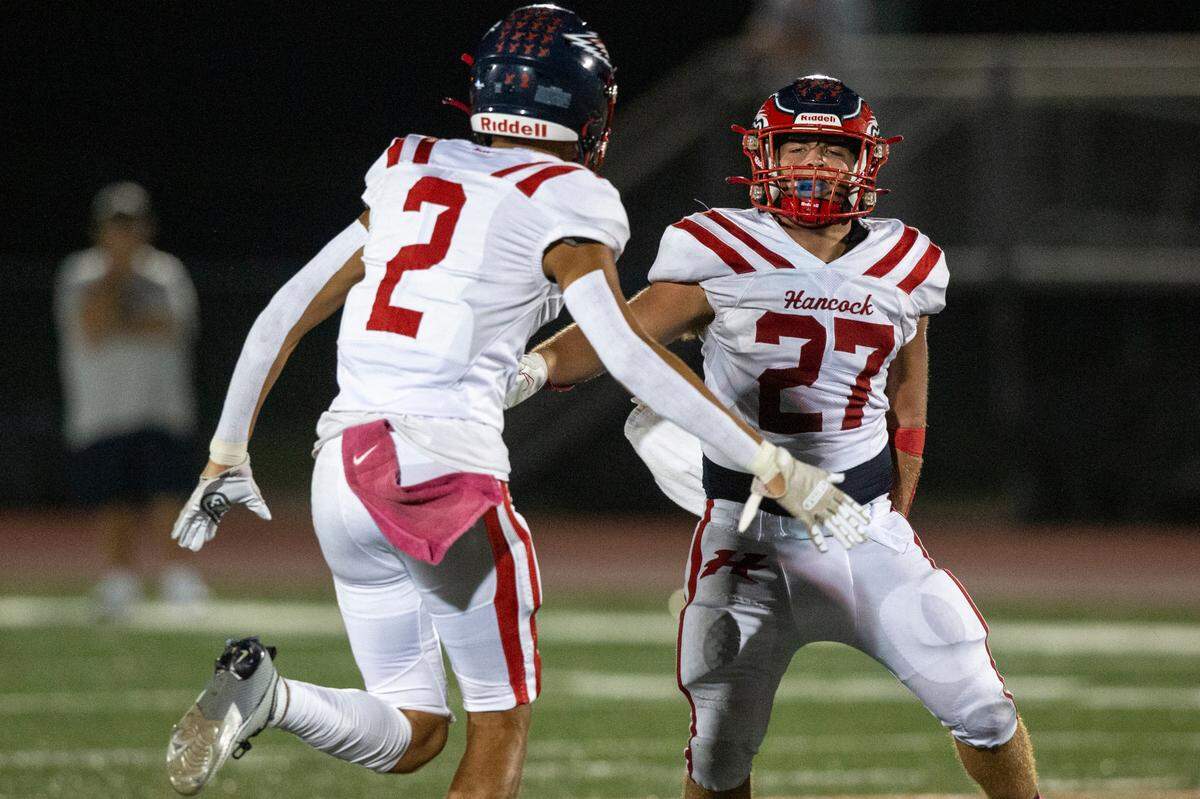 Hancock’s Jeffery Hopgood, right, and Donte Taylor celebrate after a play during a game at West Harrison High School in Harrison County on Friday, Oct. 6, 2023.