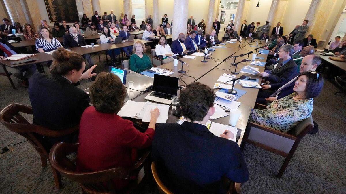 Members of the Mississippi House of Representatives Medicaid Committee listen Tuesday as representatives from the Hilltop Institute, a nonpartisan research organization, left, present a brief on the economic impact of Medicaid expansion in the state to the legislators, media and lobbyists at the state Capitol in Jackson.
