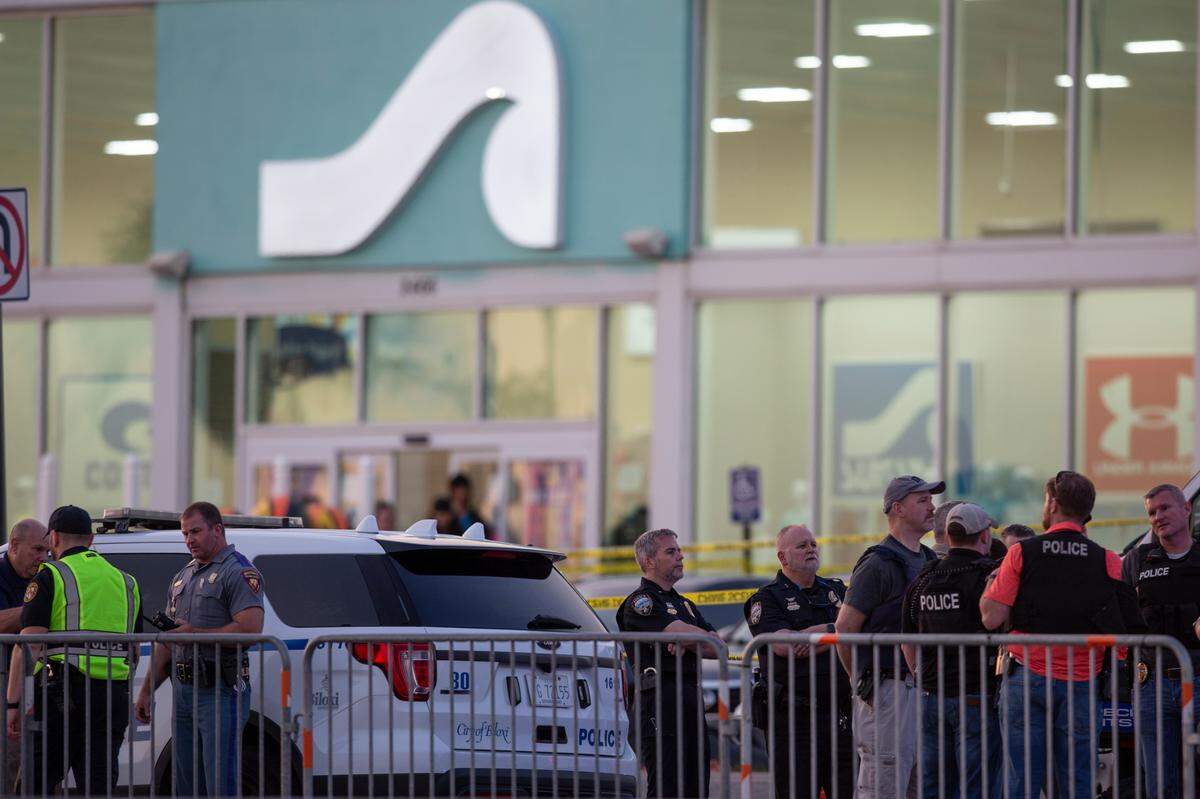 Law enforcement officers stand outside Surf Style in Biloxi after a chaotic shooting during Black Spring Break that left one police officer injured on Sunday, April 16, 2023.
