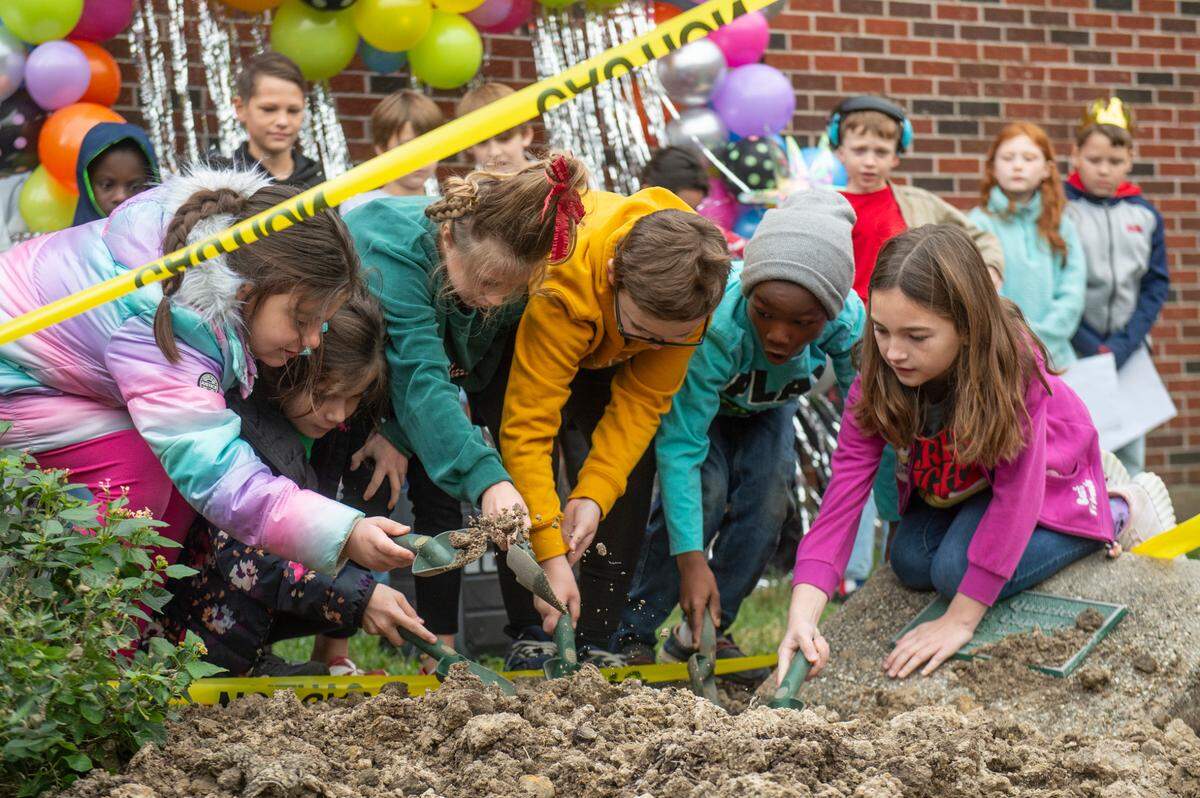 Students at W. J. Quarles Elementary in Long Beach help to dig up a time capsule from 1999 on Friday, Dec. 13, 2024.