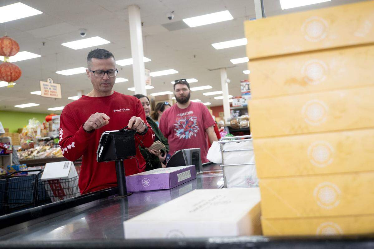 Customers purchase king cakes at Lee’s International Market in Biloxi on Friday.