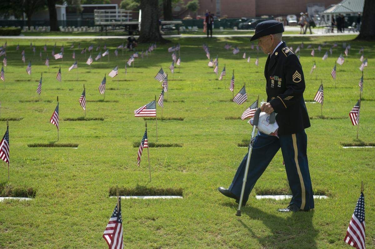 Veterans walk through the headstones at Biloxi National Cemetery in Biloxi for Memorial Day on Monday, May 26, 2025.