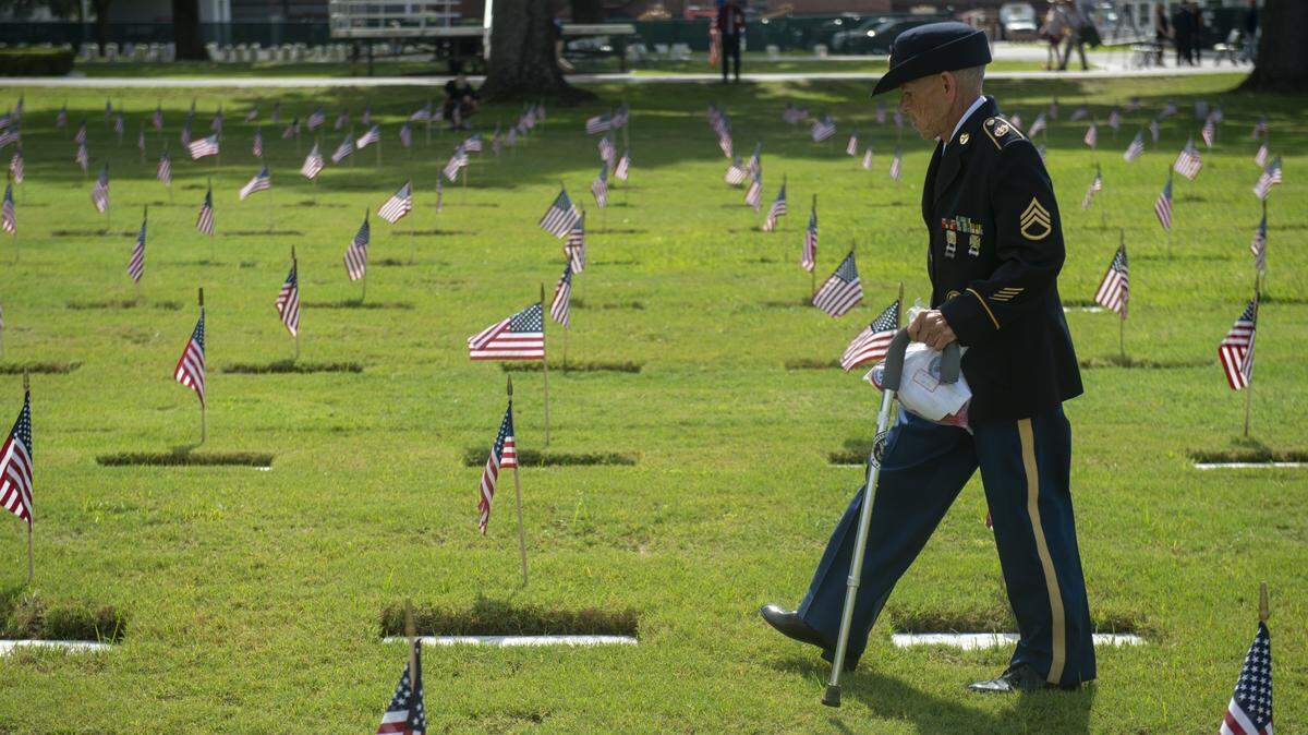 Veterans walk through the headstones at Biloxi National Cemetery in Biloxi for Memorial Day on Monday, May 26, 2025.