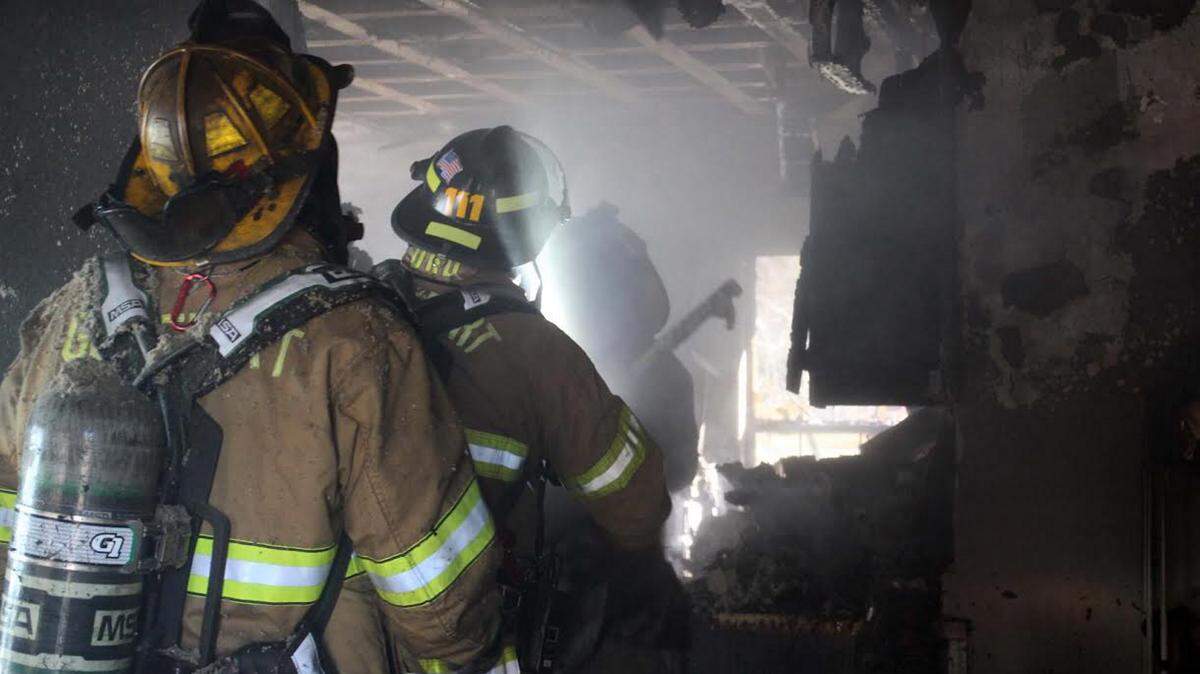 COURTESY PAT SULLIVAN 
 Firefighters work to extinguish a house fire near South Boulevard and Canal Road on Friday afternoon.