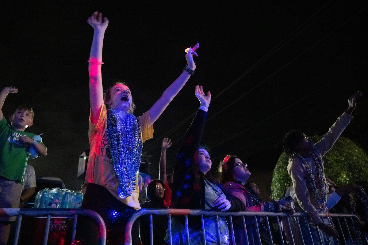 Children cheer for throws from parade floats during the Krewe of Neptune parade in Biloxi on Saturday, Feb. 14, 2026.