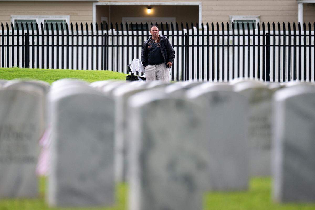 An event attendee gazes at rows of tombstones after a ceremony at Biloxi National Cemetery on Monday, May 25, 2026.