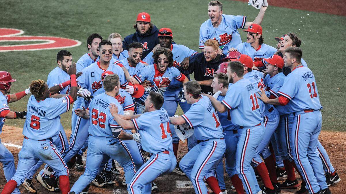 BRUCE NEWMAN/ASSOCIATED PRESS 
 Ole Miss' Henri Lartigue (22) is mobbed by his teammates following his three run home run in the bottom of the ninth inning to beat Kentucky 7-5 on Saturday at Swayze Field.